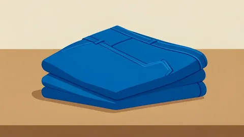 A neatly folded stack of blue denim jeans on a wooden table
