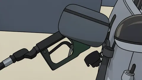 A fuel pump nozzle resting on a gas station island