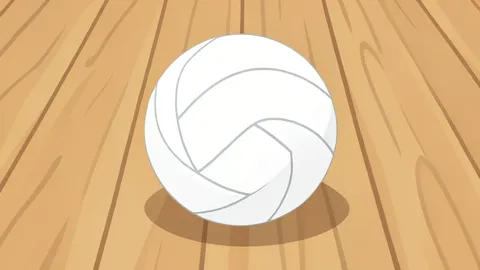 A white volleyball resting on a polished wooden gymnasium floor