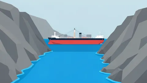 A large oil tanker ship moving through a narrow strait between rocky coastlines