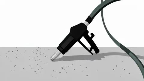 A fuel pump nozzle resting on the concrete forecourt of a gas station