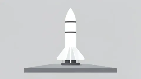 A white rocket booster standing vertically on a concrete launch pad