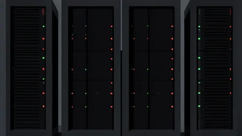 A row of industrial server racks with blinking status lights in a dark data center