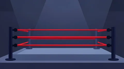 A wrestling ring with red ropes and turnbuckles in a dimly lit arena