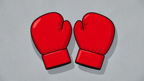 A pair of red boxing gloves resting on a worn canvas ring floor