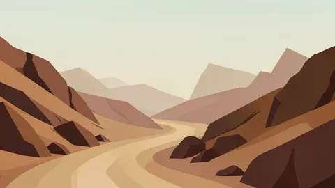 A dusty, arid landscape with a winding dirt road cutting through rocky hills under a hazy sky