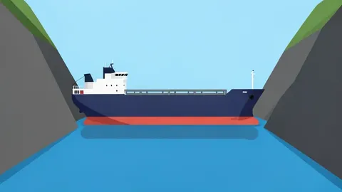 A large bulk carrier ship floating on the water in a narrow strait