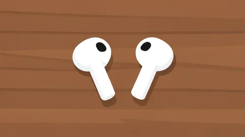 A pair of wireless earbuds resting on a wooden surface