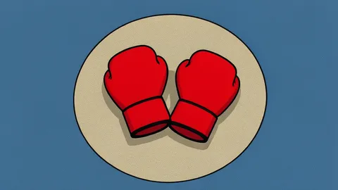 A pair of red boxing gloves resting on a canvas ring floor