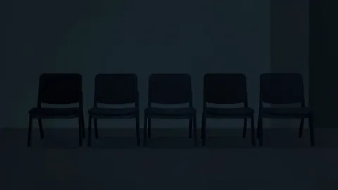 A row of empty chairs in a dimly lit room