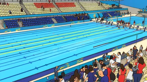 A large indoor swimming pool with blue water and lane ropes