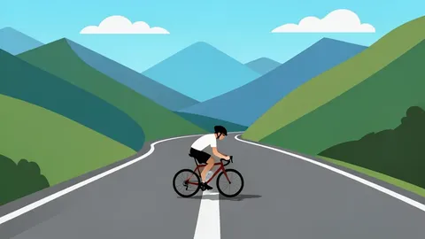 A winding mountain road with a single cyclist riding a drop-bar bicycle