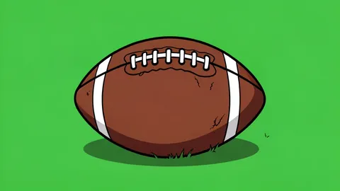A worn leather American football resting on a green grass field